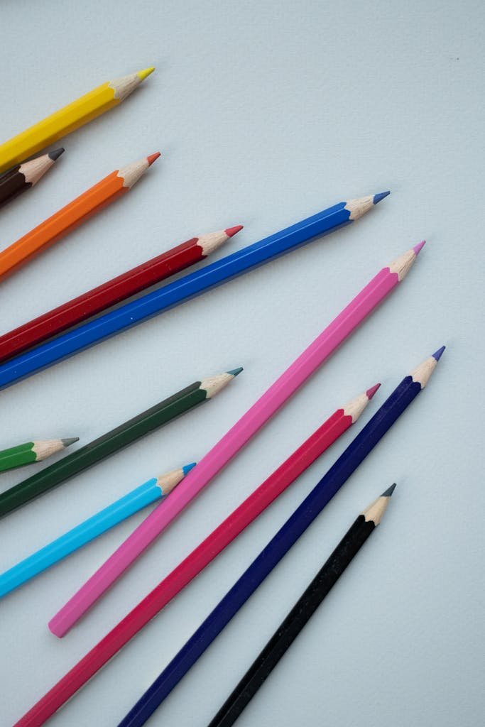 Assorted colored pencils arranged on a light background creating a vibrant artistic display.